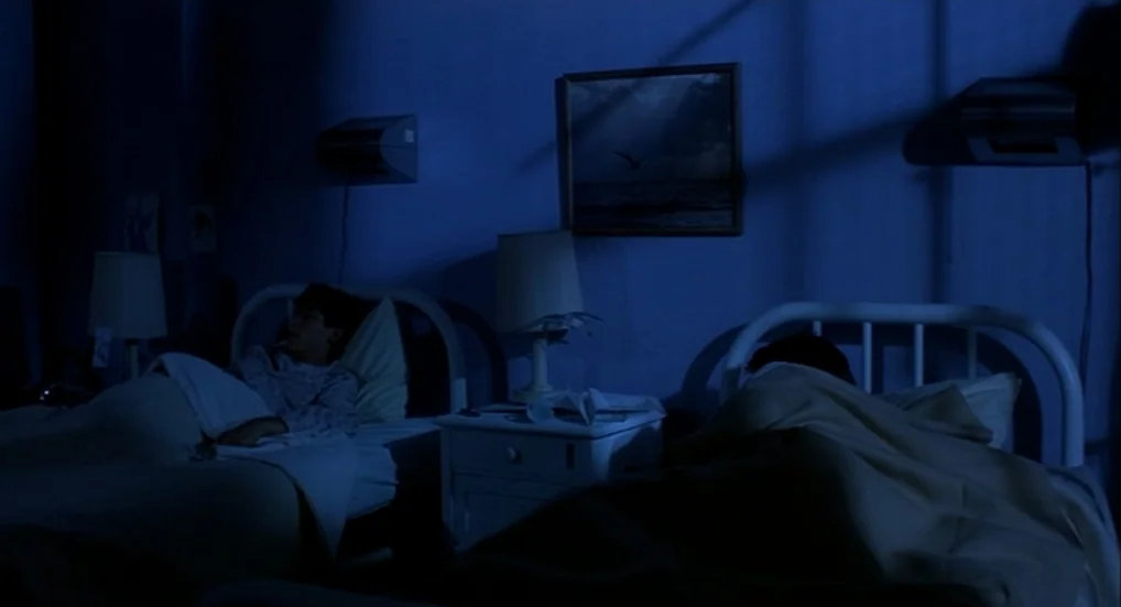 A Nightmare On Elm Street 3: Dream Warriors (1987) movie still: wide — A dimly lit room at night contains two single beds positioned side by side.…