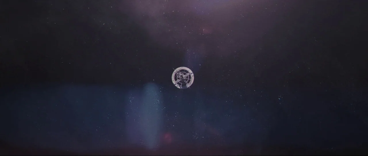 The Last Days On Mars (2013) movie still: wide — A small circular space station floats in the center of a dark cosmic void. Wispy purple nebulae and…