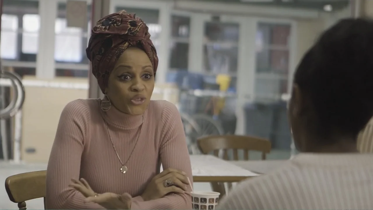 A Film Called Blacks Can't Swim (My Journey My Story) (2020) movie still: medium — An interior cafe space features light-colored tables and a…