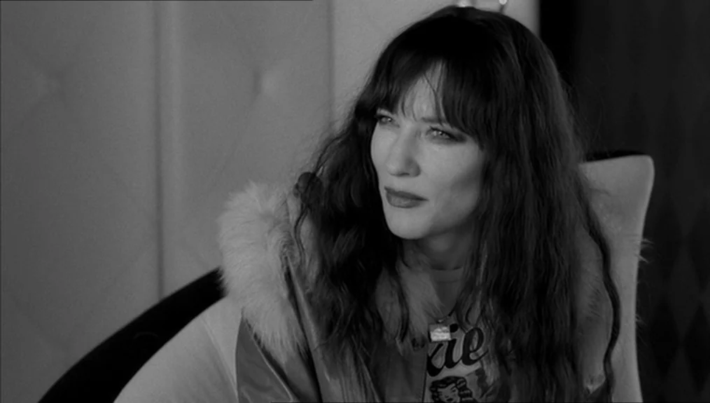 Coffee and Cigarettes (2003) movie still: closeup — A close-up shot of a woman with long wavy hair sitting in an interior space. She wears a jacket…