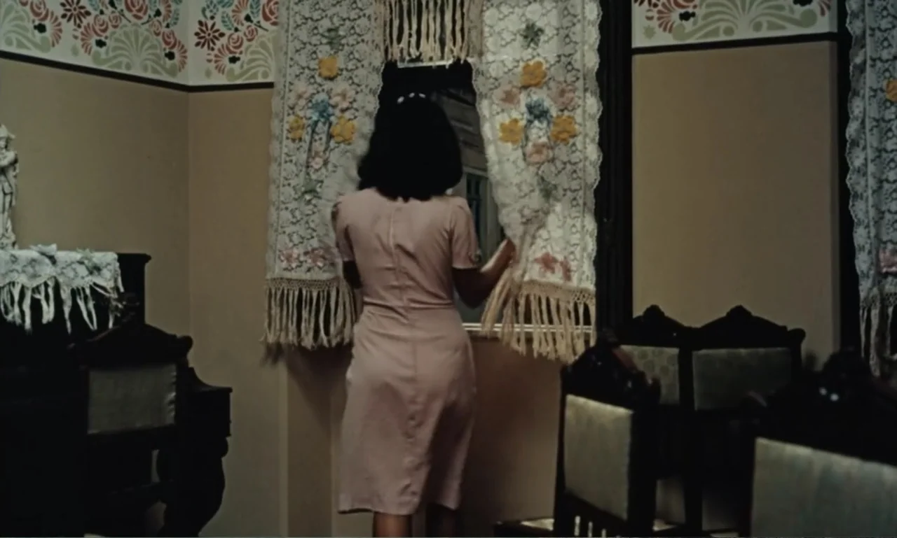 Dona Flor and Her Two Husbands (1976) movie still: medium — An interior space features patterned wall stenciling and dark wooden furniture. A woman…