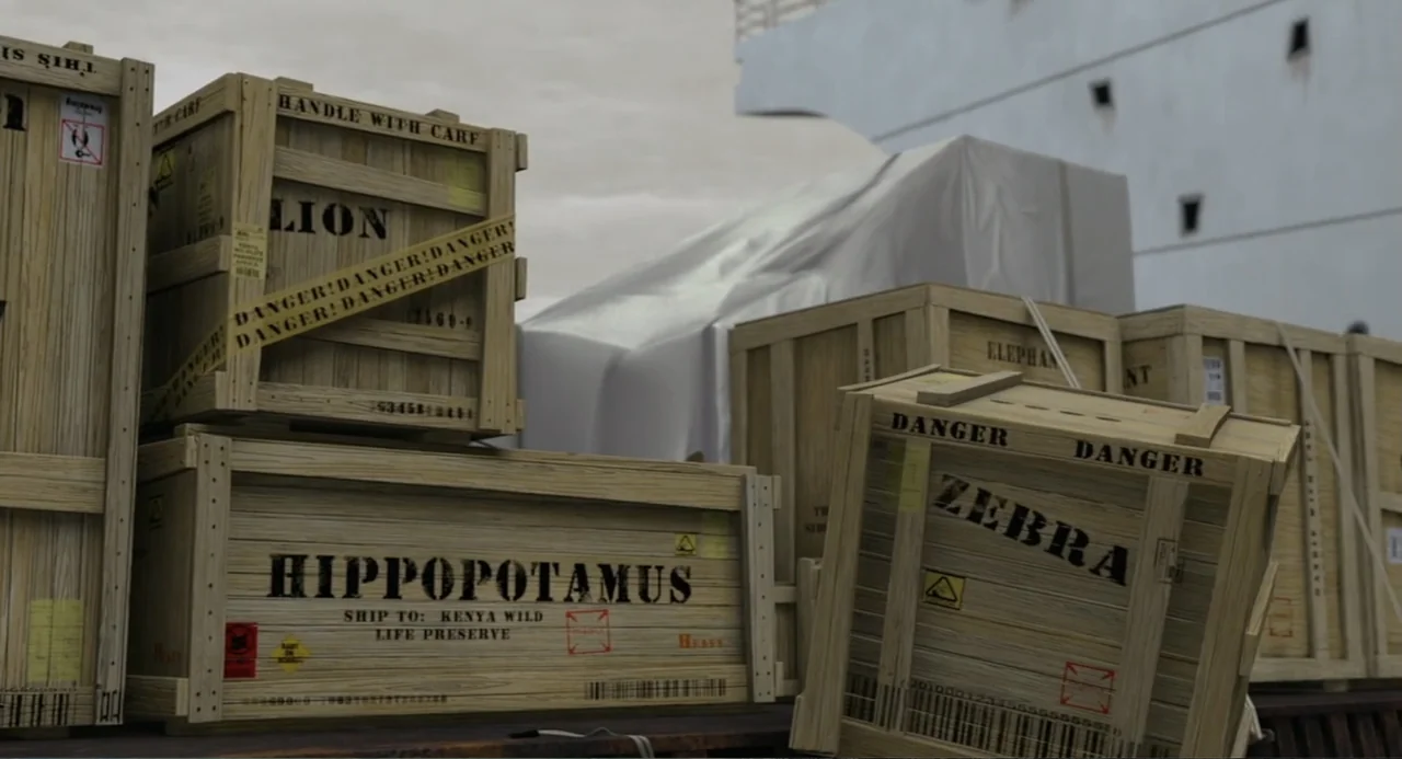 Madagascar (2005) movie still: medium — Multiple wooden shipping crates marked with animal names sit on a cargo deck. A large object covered in…