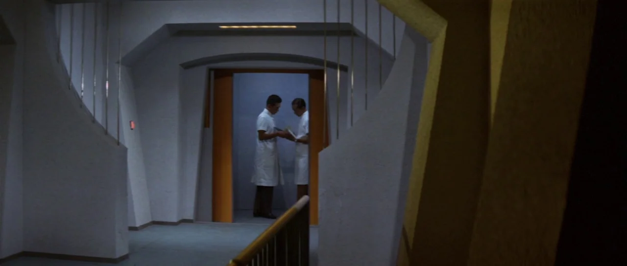 Ebirah Horror of the Deep (1966) movie still: wide — A modern, minimalist corridor features white textured walls and geometric structural elements.…