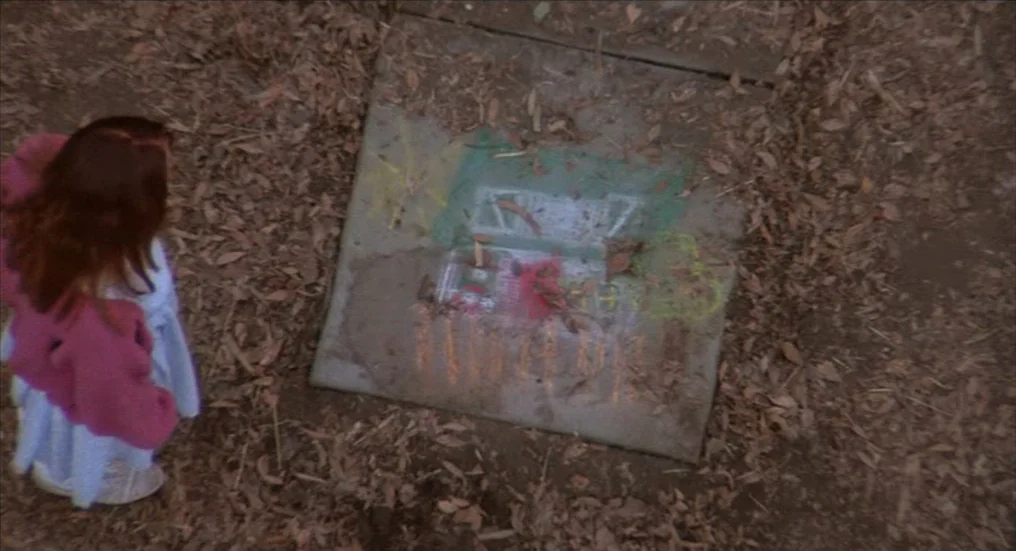 A Nightmare On Elm Street 4: The Dream Master (1988) movie still: medium — A patch of dirt is covered in scattered dry brown autumn leaves. A child…
