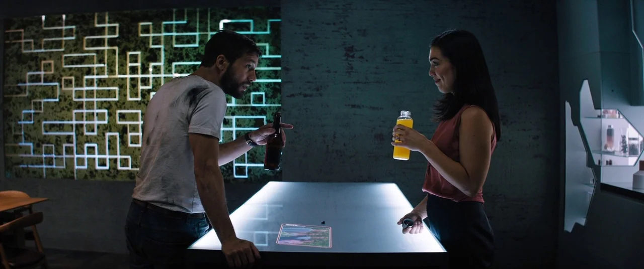 Upgrade (2018) movie still: medium — A modern kitchen space features a bright illuminated island and a wall circuit display. A man and woman stand…