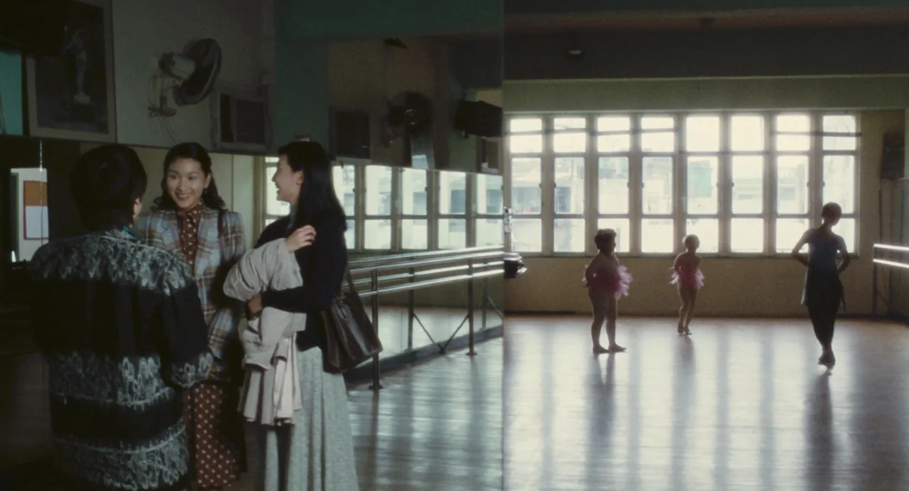 Comrades: Almost A Love Story (1996) movie still: wide — A spacious room features polished wooden floors and large wall mirrors reflecting the…