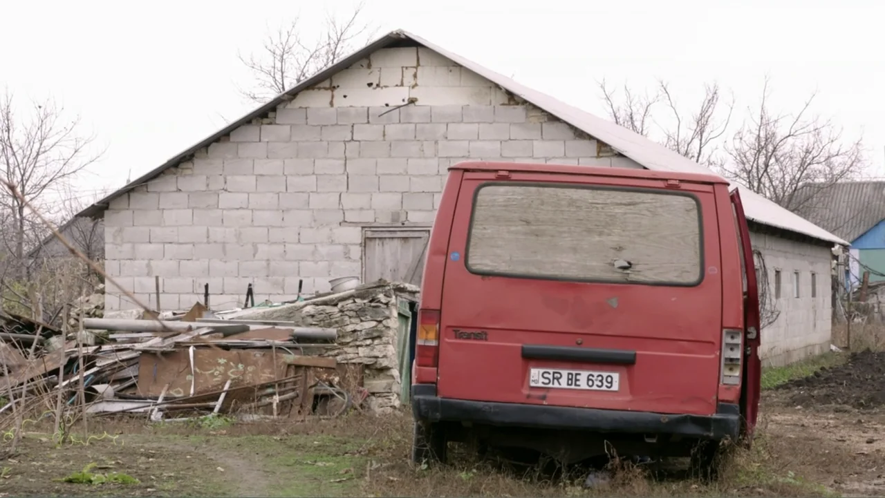 Finding the Way Home (1991) movie still: wide — A rural lot with a red cargo van parked before a cinderblock structure. Debris and stone rubble are…
