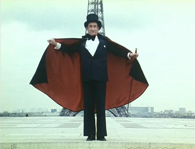 Daguerréotypes (1976) movie still: fullbody — A man stands on a wide stone plaza with the Eiffel Tower in background. The man holds his arms out to…
