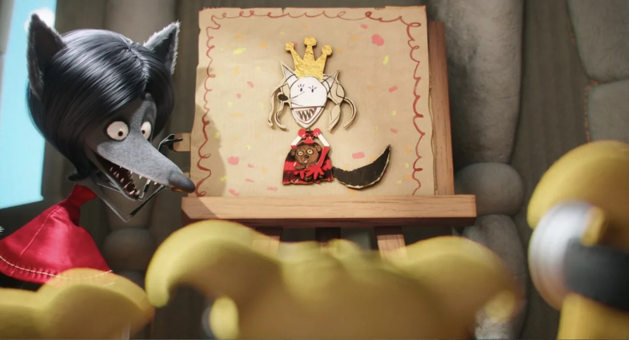Minions (2015) movie still: medium — An interior space contains a wooden easel holding a drawing of a crowned figure. A grey wolf character with…