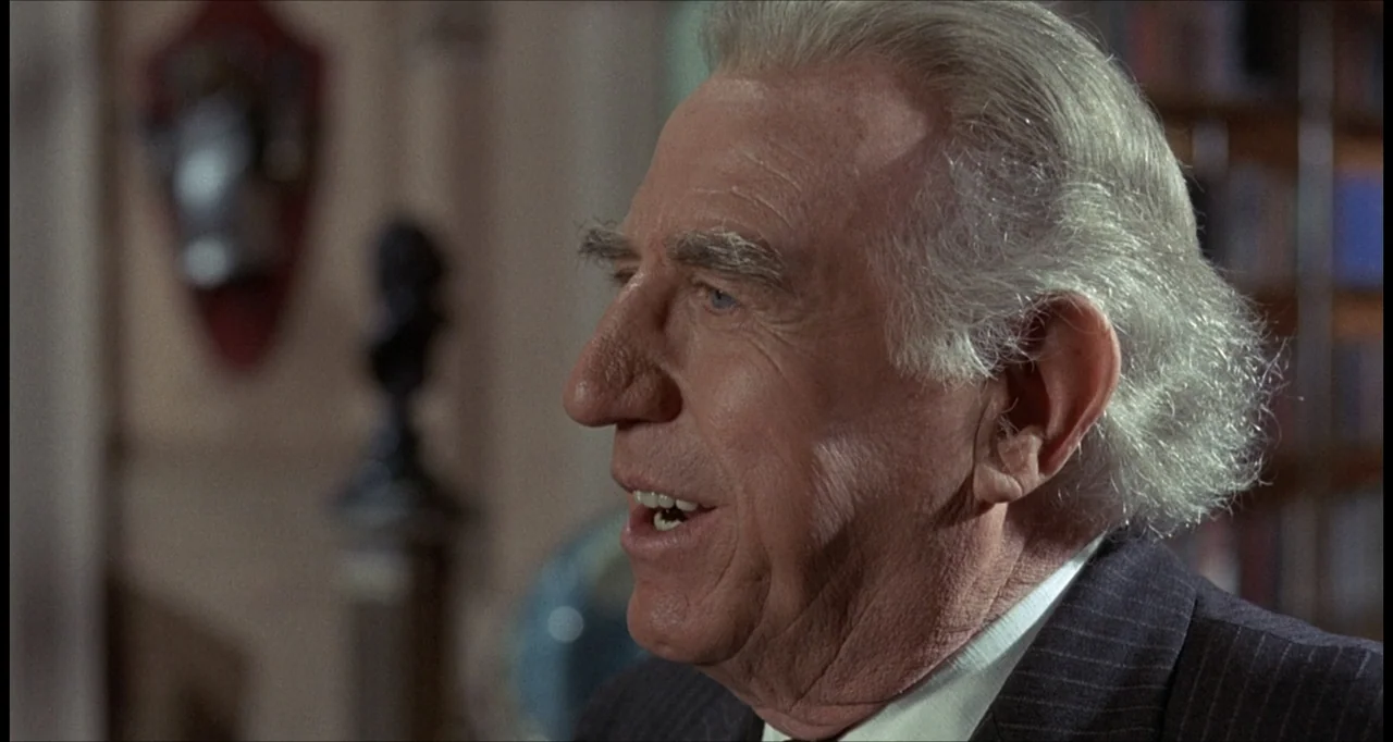 The Dunwich Horror (1970) movie still: closeup — An interior study with bookshelves visible in the background and wall decor. An elderly man in a…