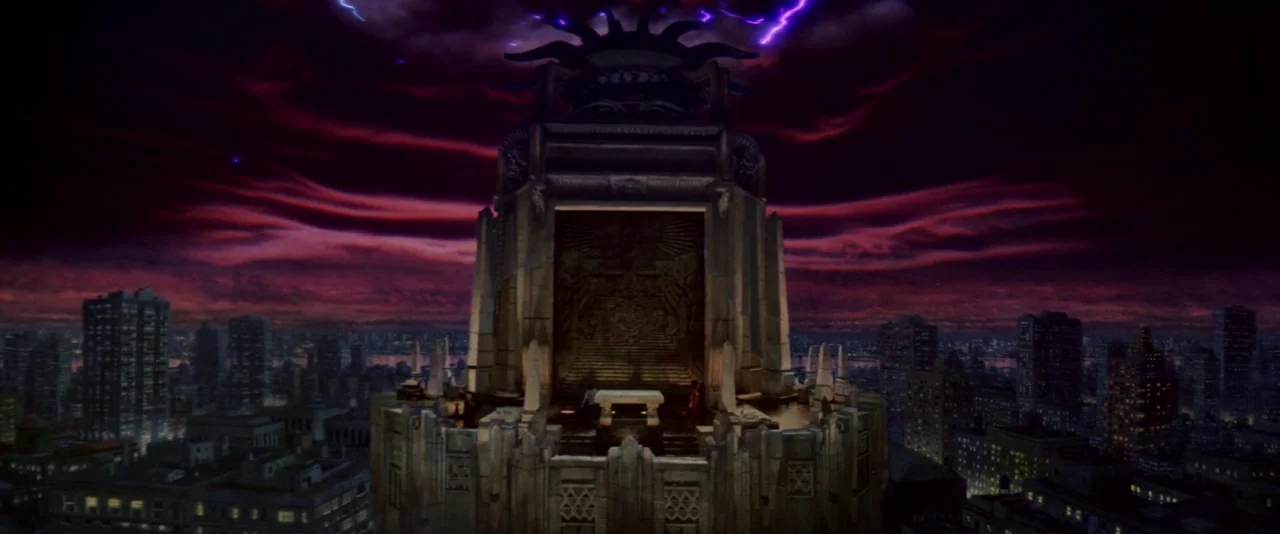 Ghostbusters (1984) movie still: establishing — An Art Deco skyscraper roof features a large ornate stone temple with a central altar. Intense…