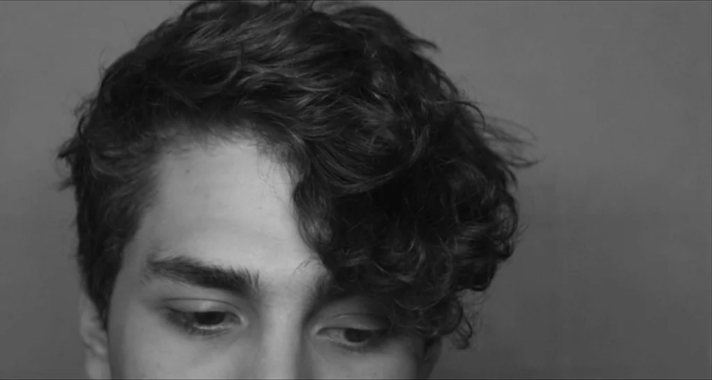 I Killed My Mother (J’ai tué ma mère) (2009) movie still: closeup — A monochromatic studio backdrop serves as the frame for a person's upper face.…