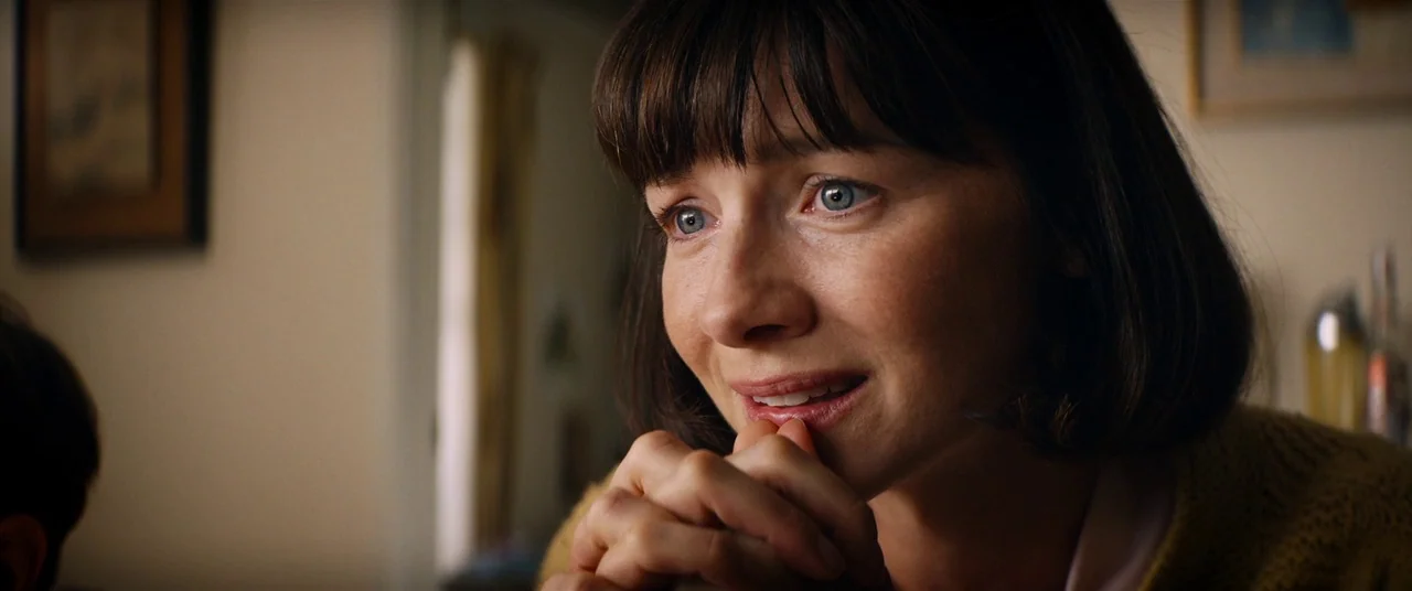 Ford V Ferrari (2019) movie still: closeup — An indoor space features a woman in a knit sweater looking toward someone. She holds her hands together…
