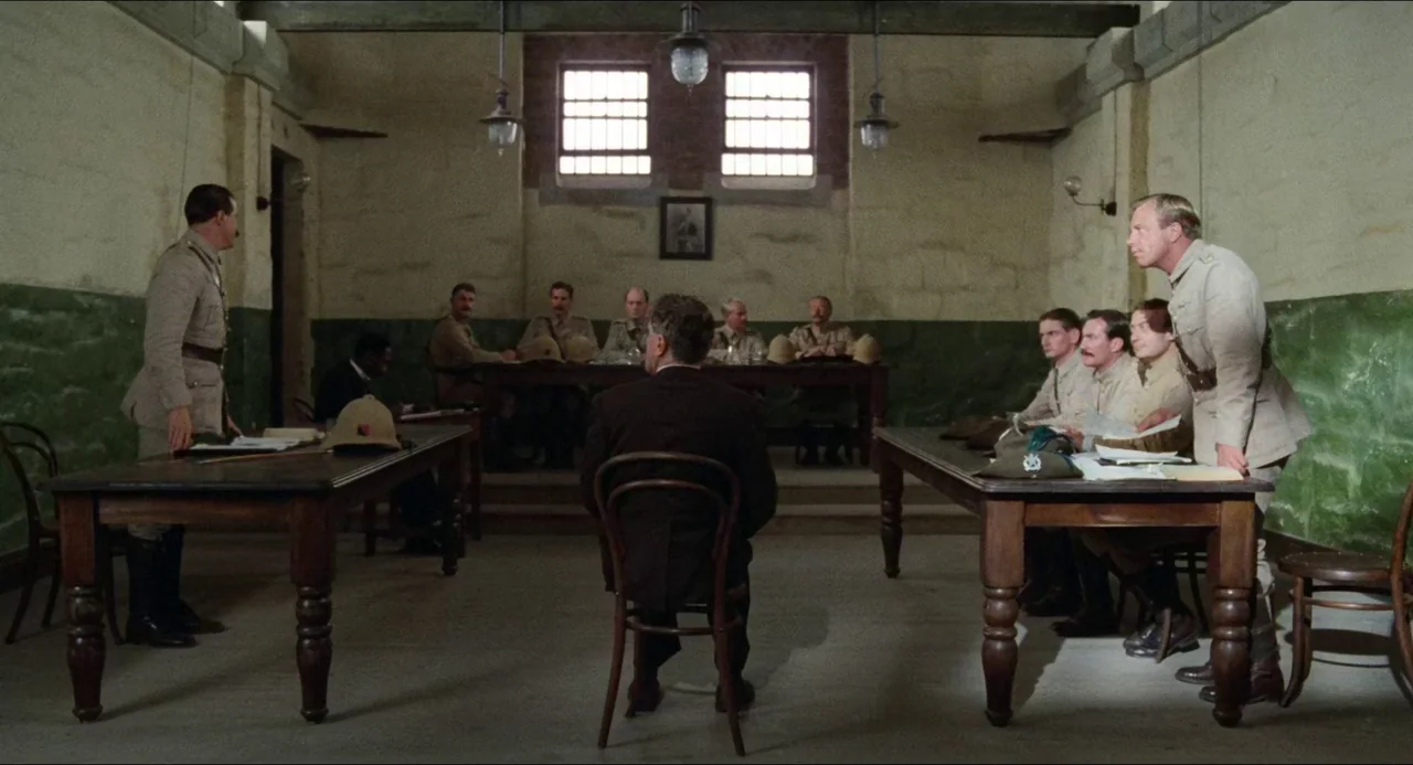 Breaker Morant (1980) movie still: wide — A austere room with stone walls and high windows serves as a formal hearing space. A lone man sits in the…