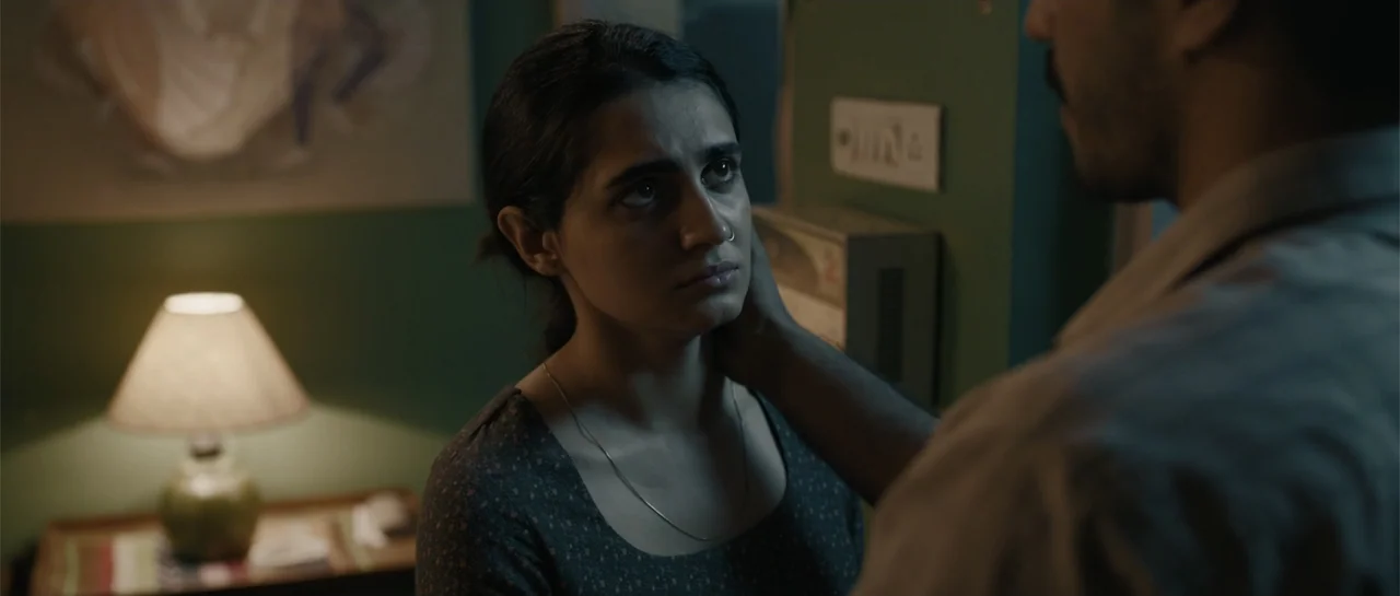 Nishaanchi 2 (2025) movie still: medium — A dimly lit room features a woman being touched by an obscured man. The warm glow of a bedside lamp…