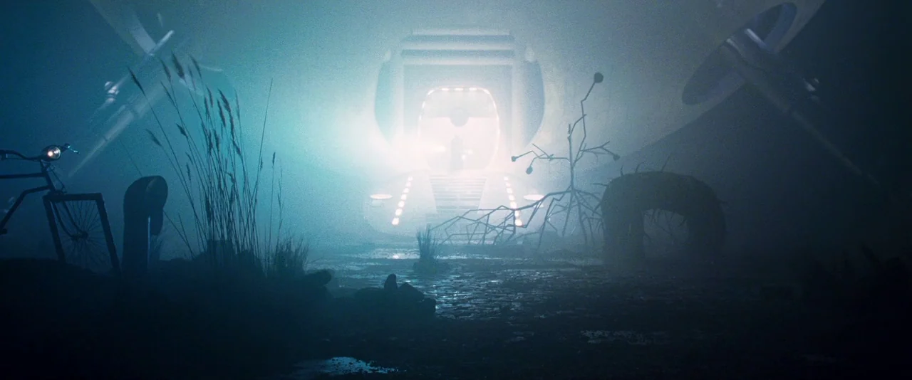 A Hitchhiker’s Guide To The Galaxy (2005) movie still: establishing — A dark muddy clearing is dominated by a glowing alien craft with open doors.…