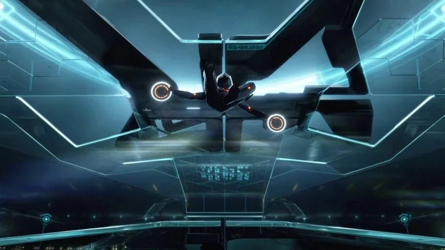 TRON: Legacy (2010) movie still: wide — A dark, angular cockpit interior features symmetric glowing cyan geometric patterns on the walls. A lone…