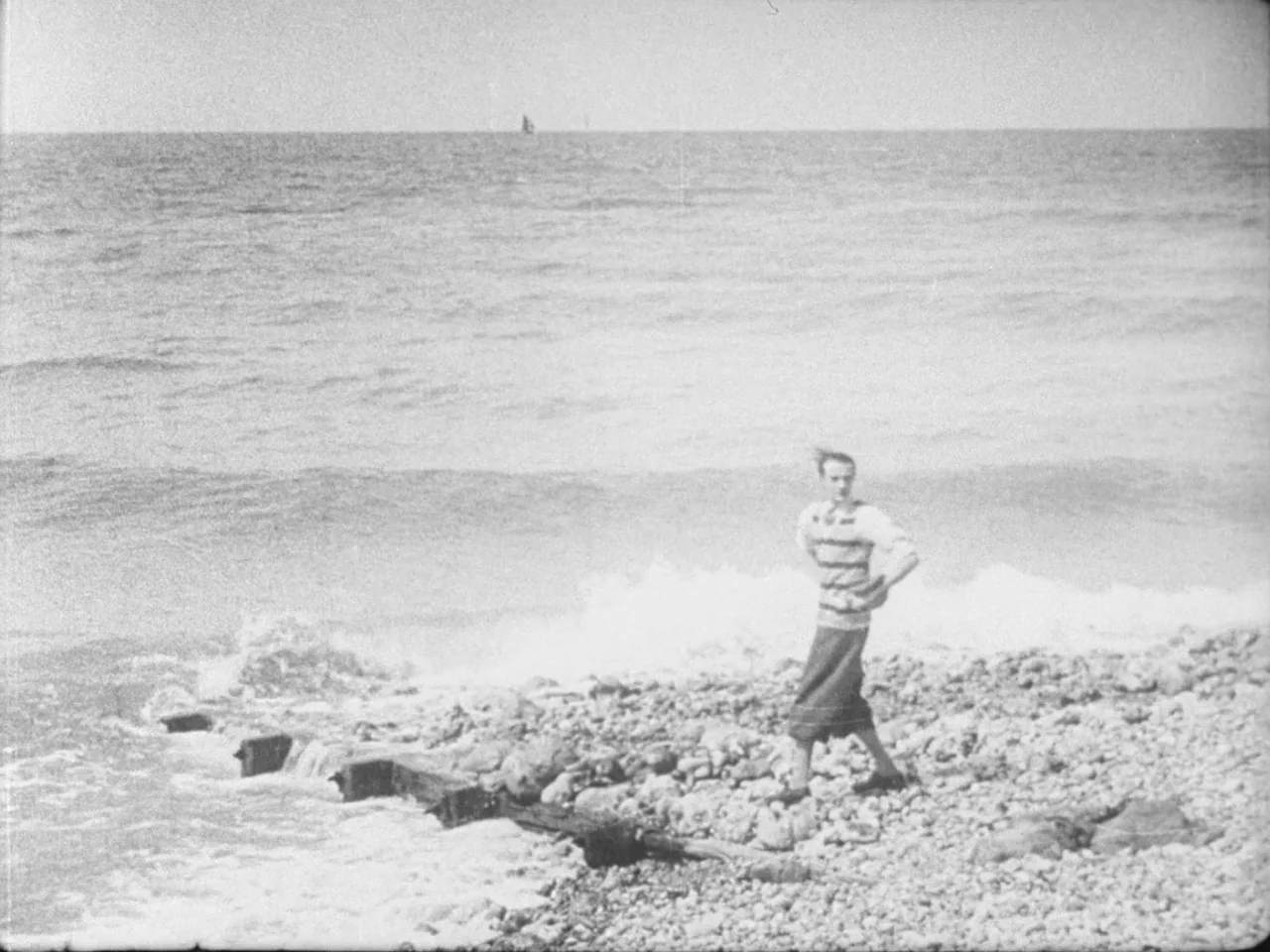 Un Chien Andalou (1929) movie still: wide — A desolate shoreline consists of rounded pebbles meeting the churning surface of the ocean. A lone…