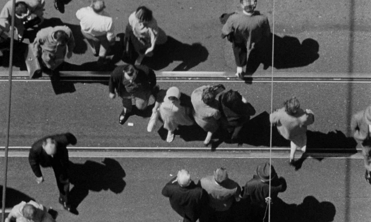Something Wild (1961) movie still: wide — A top-down view of a paved urban street with visible tram tracks running horizontally. Multiple…