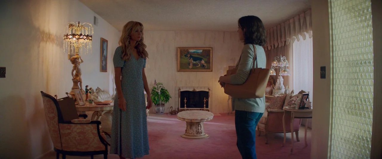 Promising Young Woman (2020) movie still: fullbody — A pink-carpeted room contains ornate antique-style furniture and a fireplace with a dog…