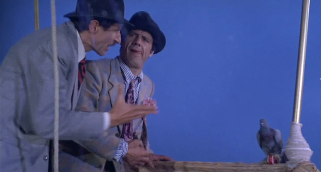 Dr. Goldfoot and the Girl Bombs (1966) movie still: medium — Two men wearing fedoras stand in a hot air balloon basket against a blue screen. One…