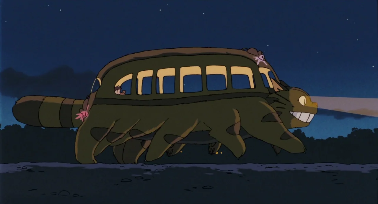 My Neighbour Totoro (1988) movie still: wide — A cat-bus creature with twelve legs runs across a dark, flat landscape at night. The creature…