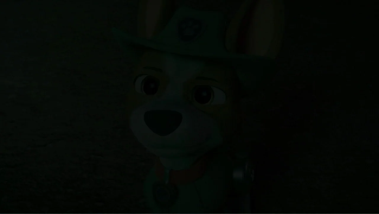 Valiente: A Tracker Story (2025) movie still: closeup — A dark outdoor setting with minimal ambient light visibility. A cartoon dog character faces…