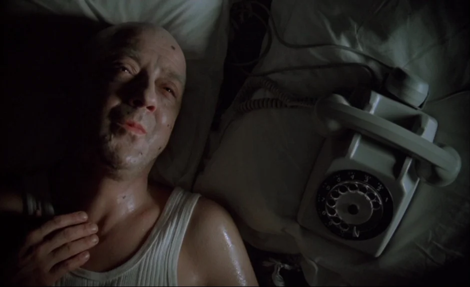 Mauvais Sang (Bad Blood) (The Night Is Young) (1986) movie still: medium — A bed with white sheets holds a man and a vintage rotary telephone. The…