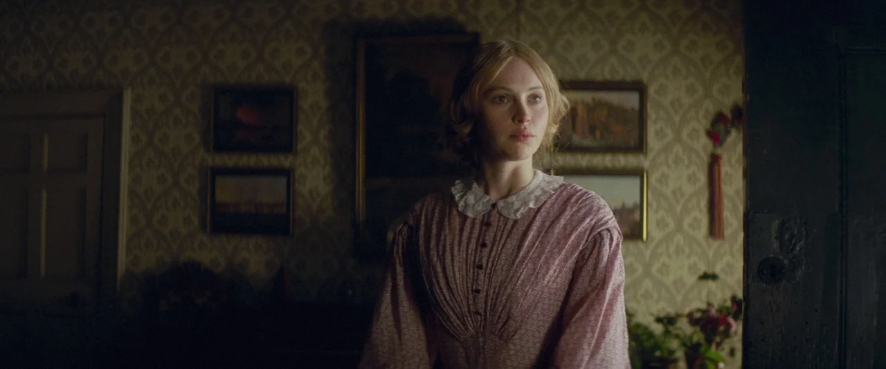 The Invisible Woman (2013) movie still: medium — An interior room features patterned Victorian wallpaper and framed paintings on the wall. A woman…
