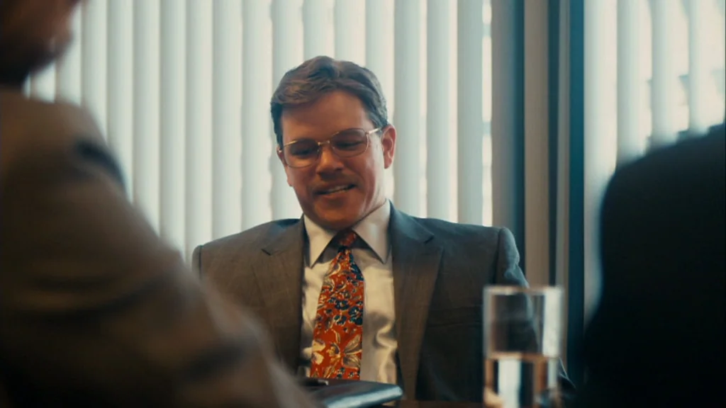 The Informant! (2009) movie still: medium — An office space with vertical window blinds providing bright, diffused backlighting. A man in a suit…