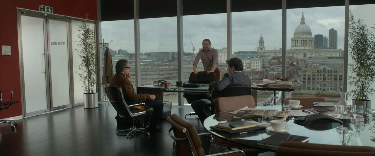 The Gentlemen (2020) movie still: wide — A modern, high-rise office overlooks a panoramic city view featuring St. Paul's Cathedral. Three men…