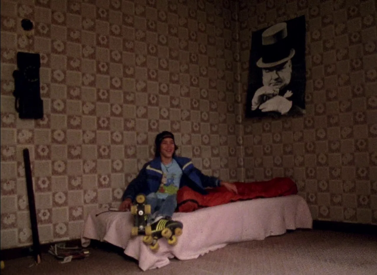 Streetwise (1984) movie still: fullbody — A bedroom features patterned 1970s style wallpaper and a large poster of Winston Churchill. A teenager…