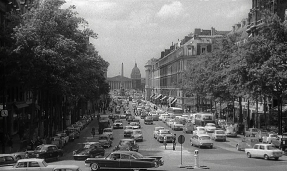 Thérèse Desqueyroux (1962) movie still: establishing — A bustling 1960s Parisian street is lined with tall, classic architecture and mature trees.…