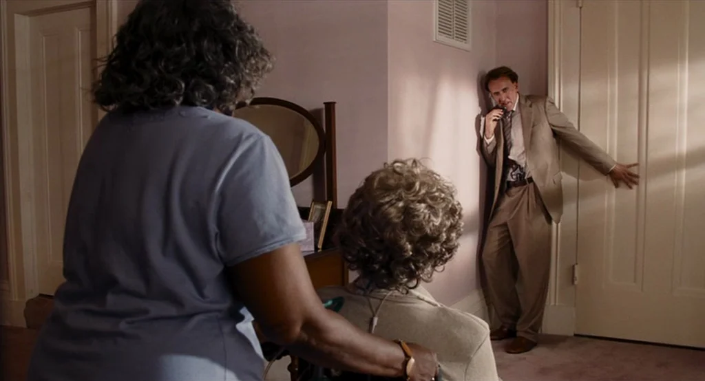 Bad Lieutenant: Port Of Call New Orleans (2009) movie still: medium — A corner of a room with pale pink walls and a closed door. A man leans against…