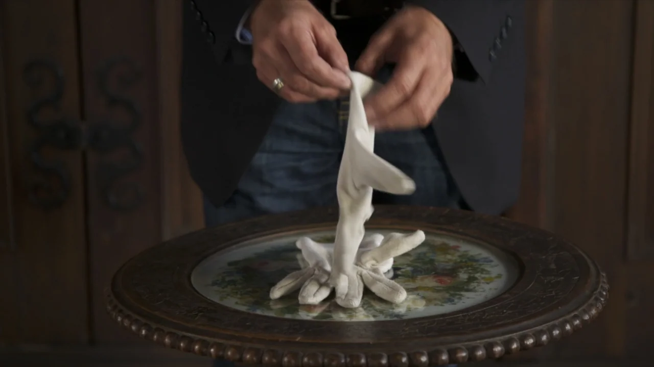 Somm: Into the Bottle (2015) movie still: medium — A person stands before a small, round table with a central floral inlay design. The person holds…