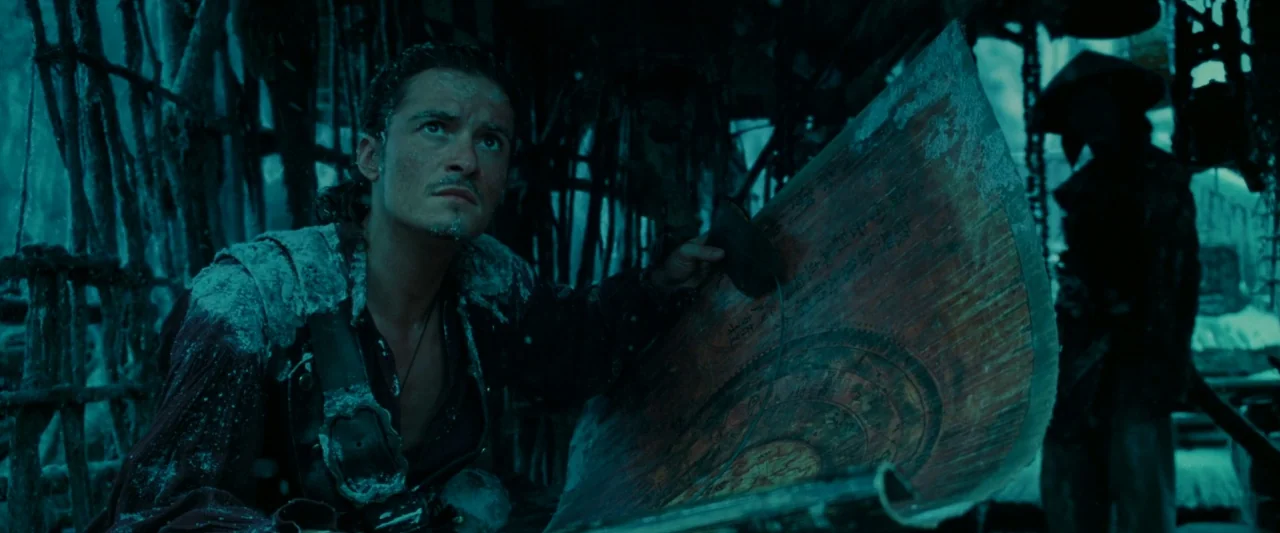 Pirates of the Caribbean: At World’s End movie still: medium — A dark wooden structure is filled with debris and draped in hanging rough materials.…