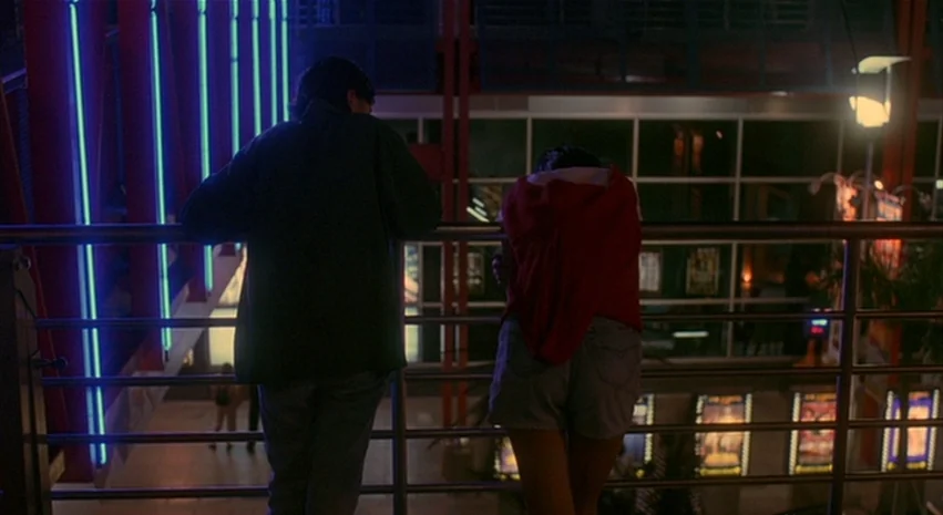 Yi-Yi (A One and A Two) (2000) movie still: fullbody — A modern multi-level lobby features blue neon lights and a grid of film posters. Two young…