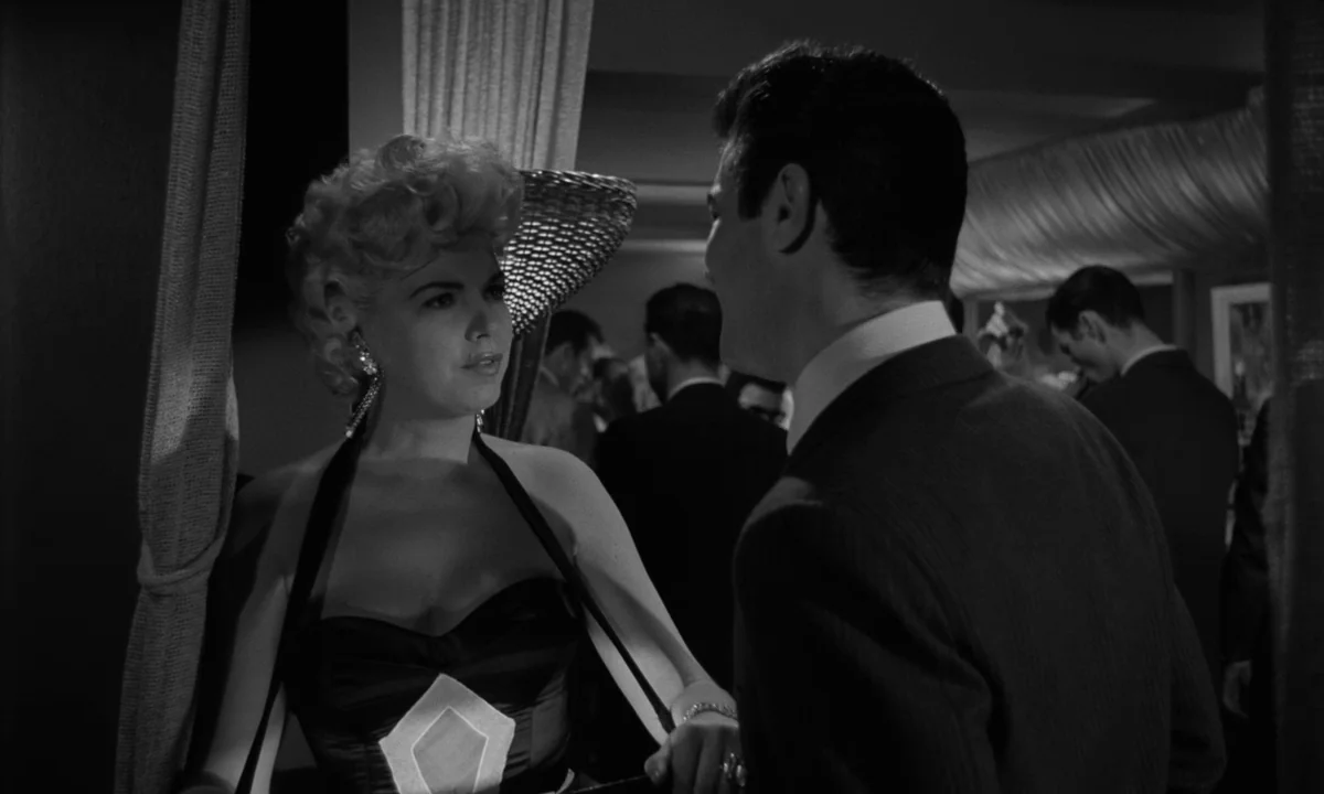 Sweet Smell of Success (1957) movie still: medium — A dimly lit nightclub with draped curtains and multiple guests visible in the background. A…