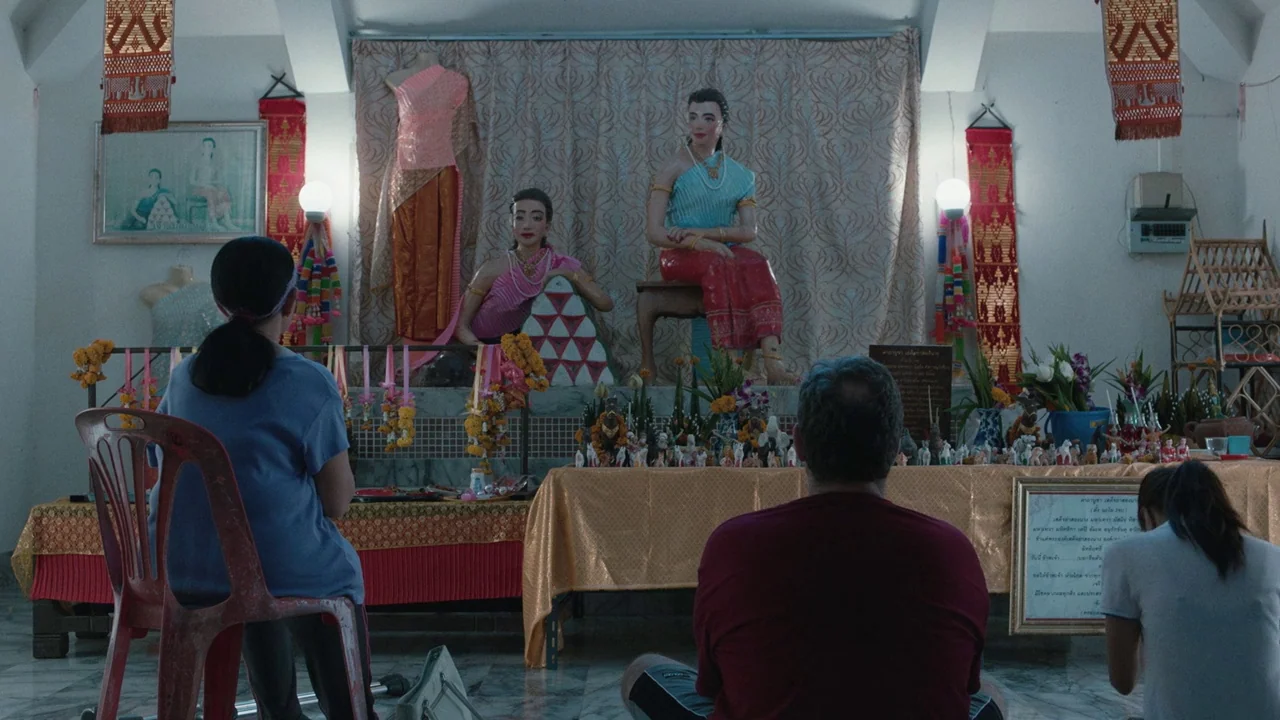 Cemetery of Splendour (2015) movie still: medium — An interior space features two life-sized mannequins styled in traditional Thai garments on a…