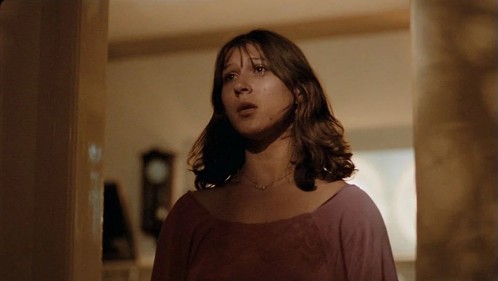 In A Year Of Thirteen Moons (1978) movie still: medium — A residential hallway features white walls and a glimpse of a dark wooden clock. A young…