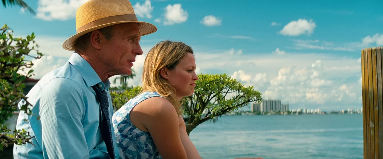 Pain & Gain (2013) movie still: medium — A wooden pier overlooks a large body of water with distant buildings visible. An older man wearing a hat…