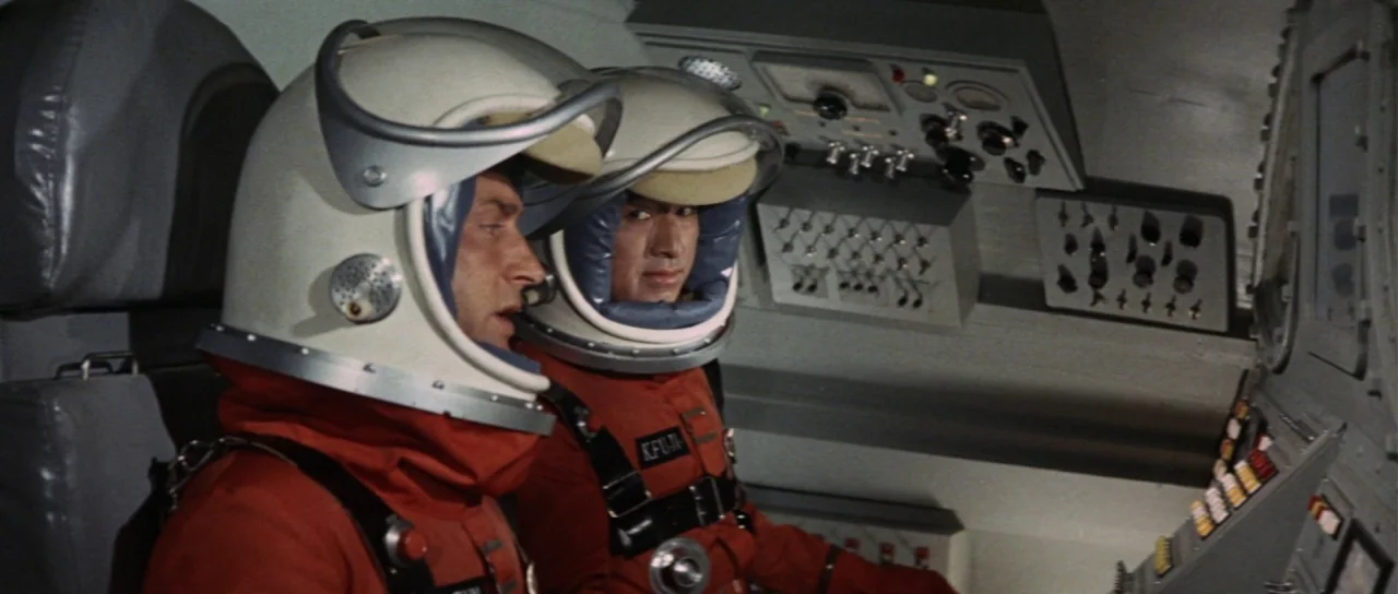 Invasion of Astro Monster (1965) movie still: medium — A tightly packed control deck features numerous switches and dials on grey panels. Two…