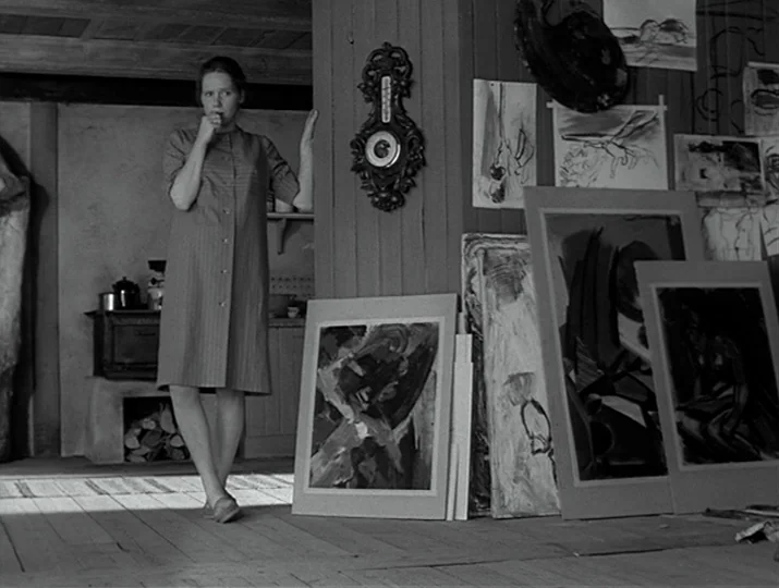 Hour of the Wolf (1968) movie still: fullbody — A rustic workspace filled with numerous abstract paintings leaning against walls and a wooden…