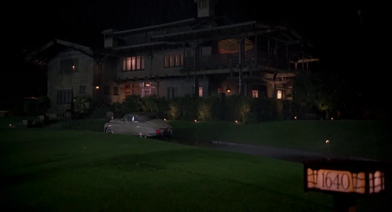 Back To The Future Part III (1990) movie still: establishing — A large two-story house stands behind a manicured lawn at night. A vintage…