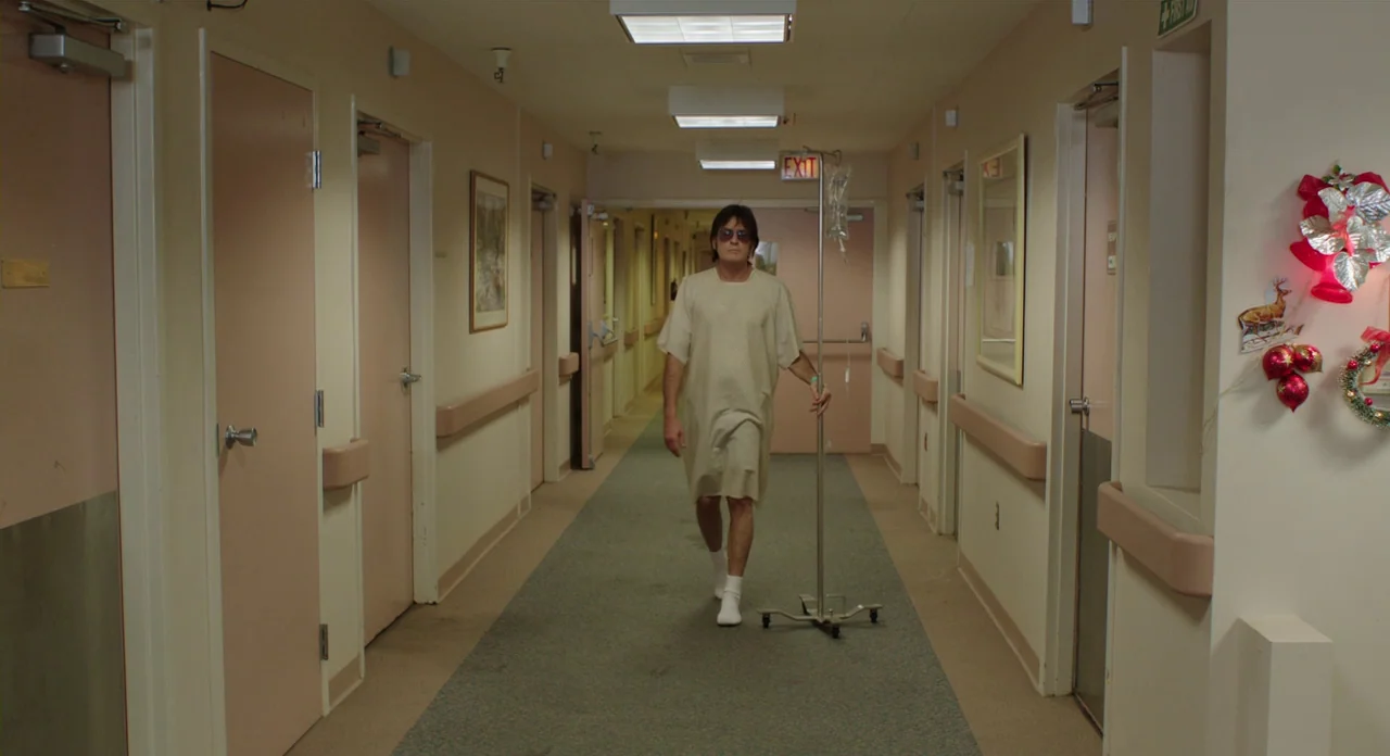 A Glimpse Inside The Mind Of Charles Swan III (2013) movie still: fullbody — A long, beige hospital hallway features closed patient doors and…