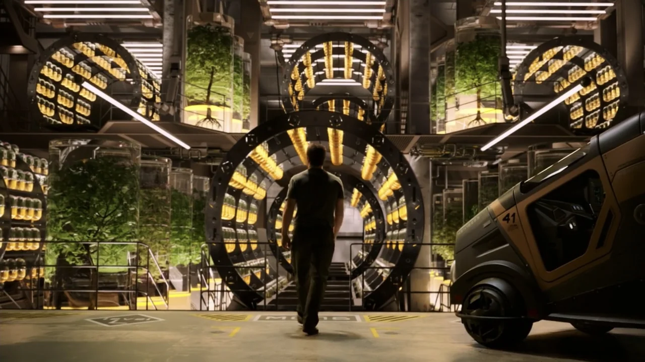 Passengers (2016) movie still: fullbody — A high-tech industrial laboratory featuring vertical plant growth cylinders and a central circular…