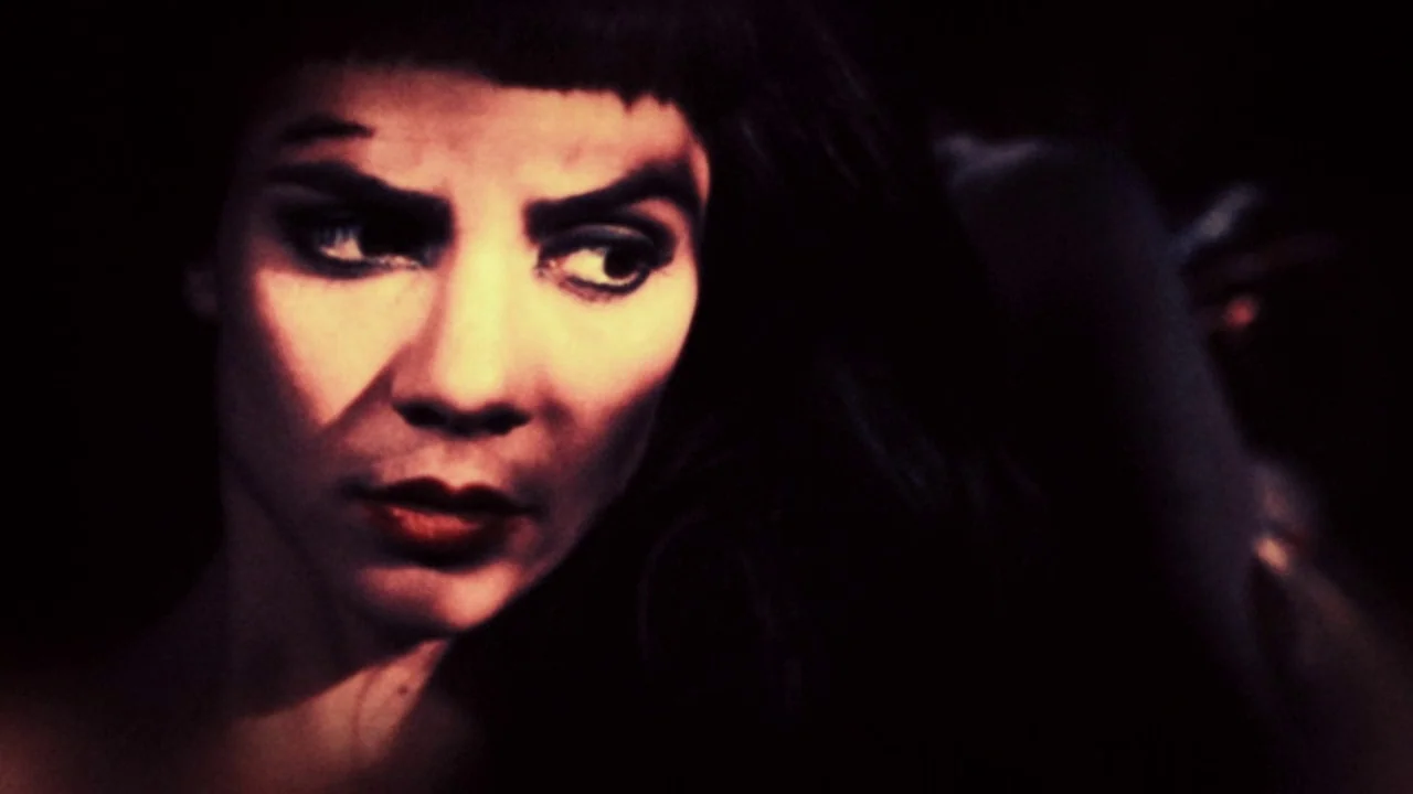 The Forbidden Room (2015) movie still: closeup — A dimly lit space features a woman in extreme close-up. She looks to the side while shadows obscure…
