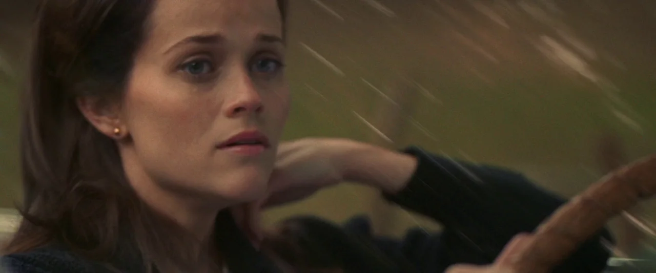 Walk The Line (2005) movie still: closeup — A woman driving a car through a landscape blurred by speed. The interior of the vehicle is visible as…