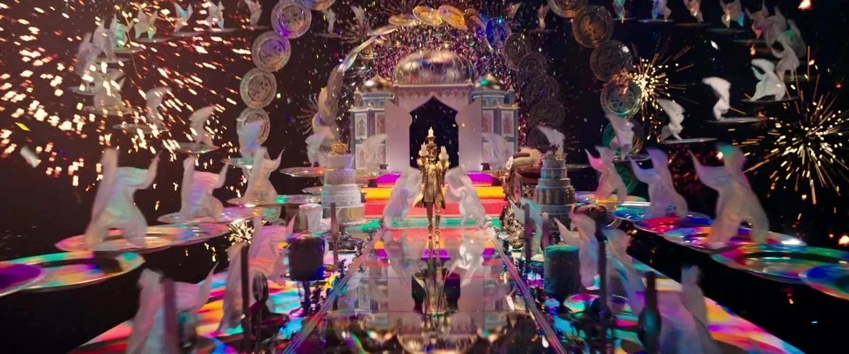 Beauty and the Beast (2017) movie still: wide — A vast hall features a long reflective central table surrounded by floating white cloth figures. The…