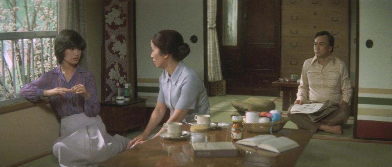Take Me Away! (1978) movie still: medium — A traditional Japanese room with tatami mats, sliding screens, and a low wooden table. Three people are…